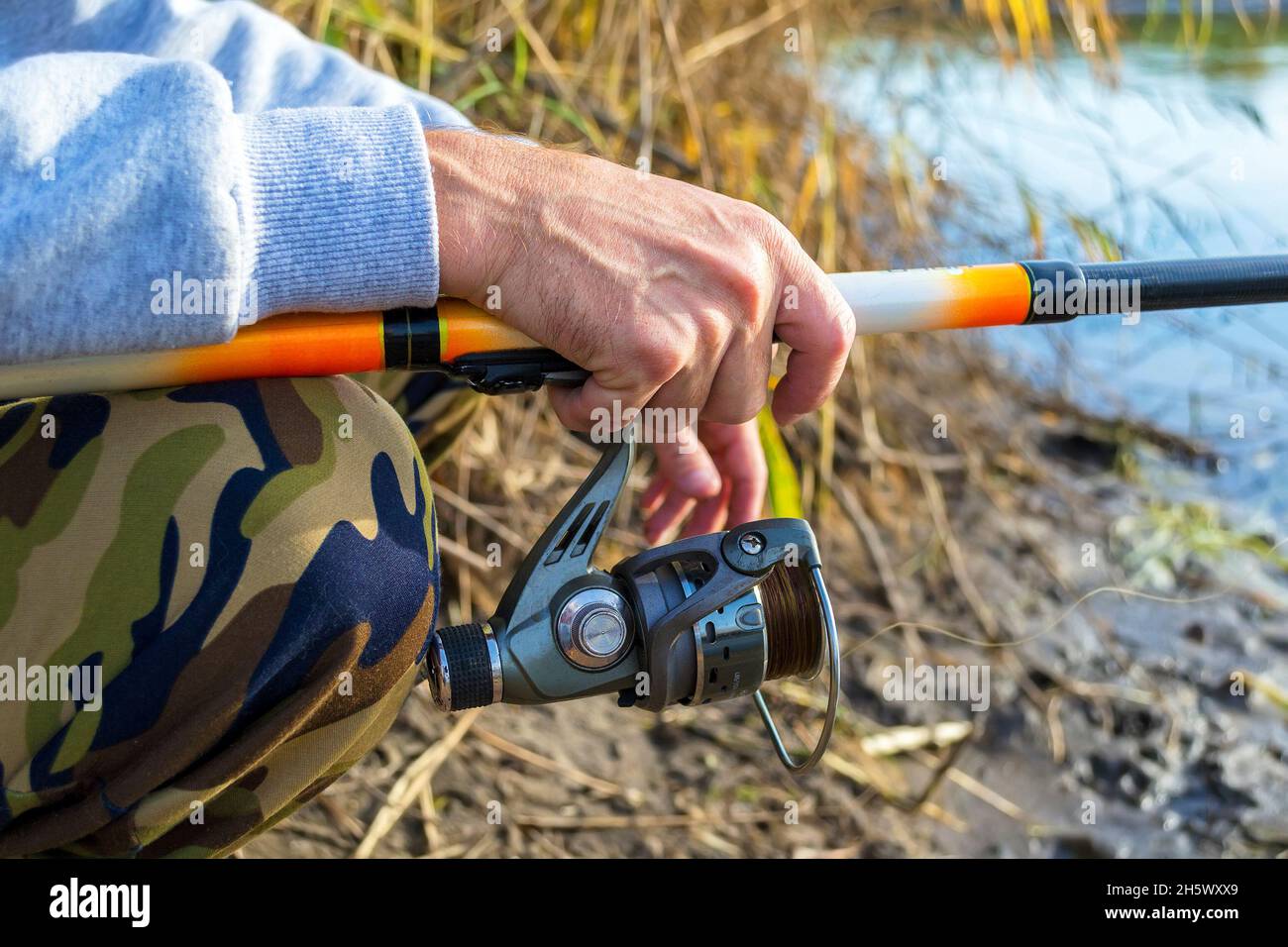 Hands fisherman holding fishing rod hi-res stock photography and