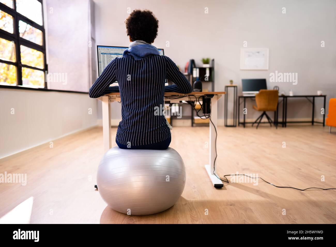 African American Lady Using Exercise Ball For Healthy Posture Stock Photo