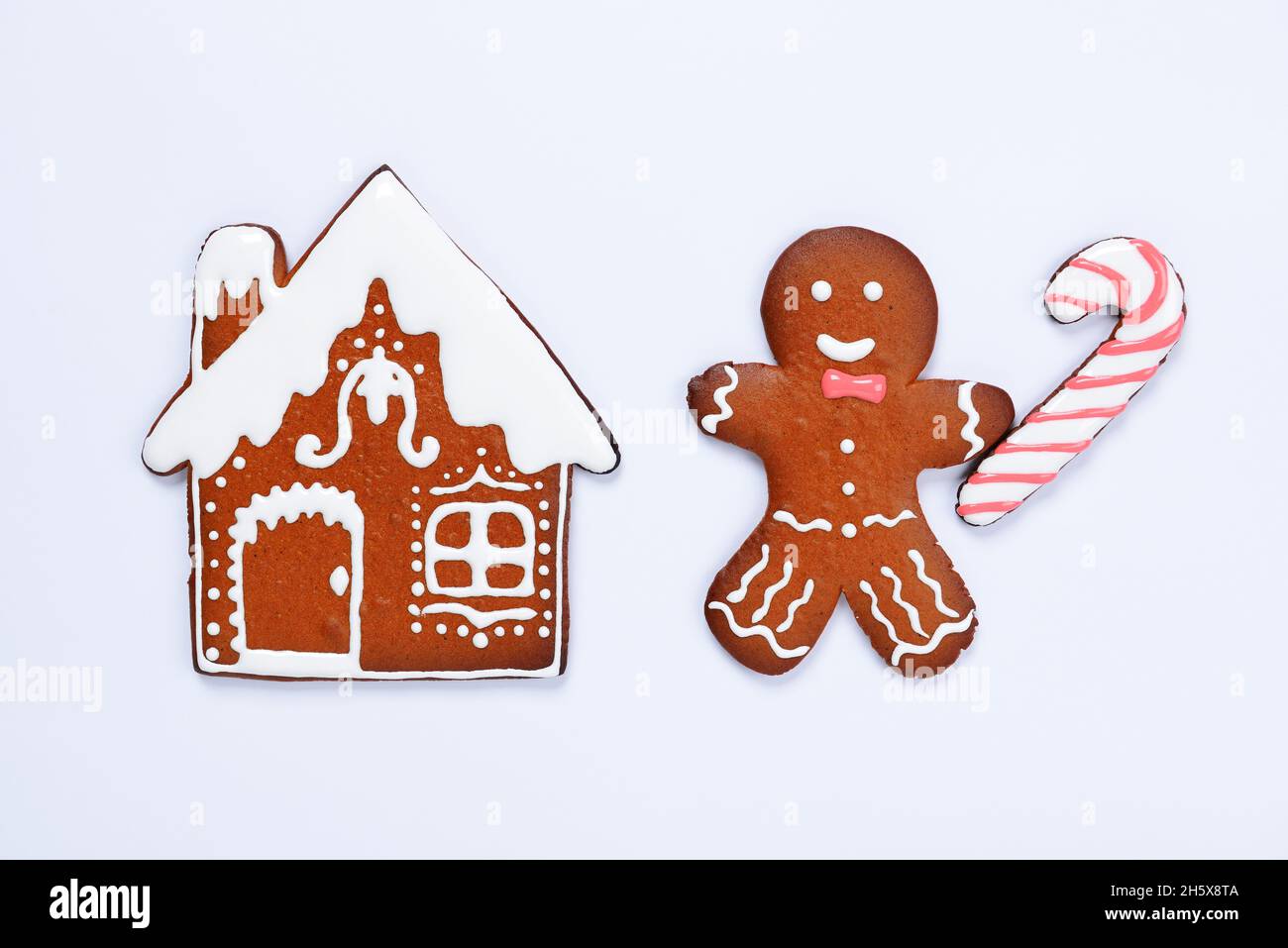 The hand-made eatable gingerbread house, little man with caramel on blue background Stock Photo