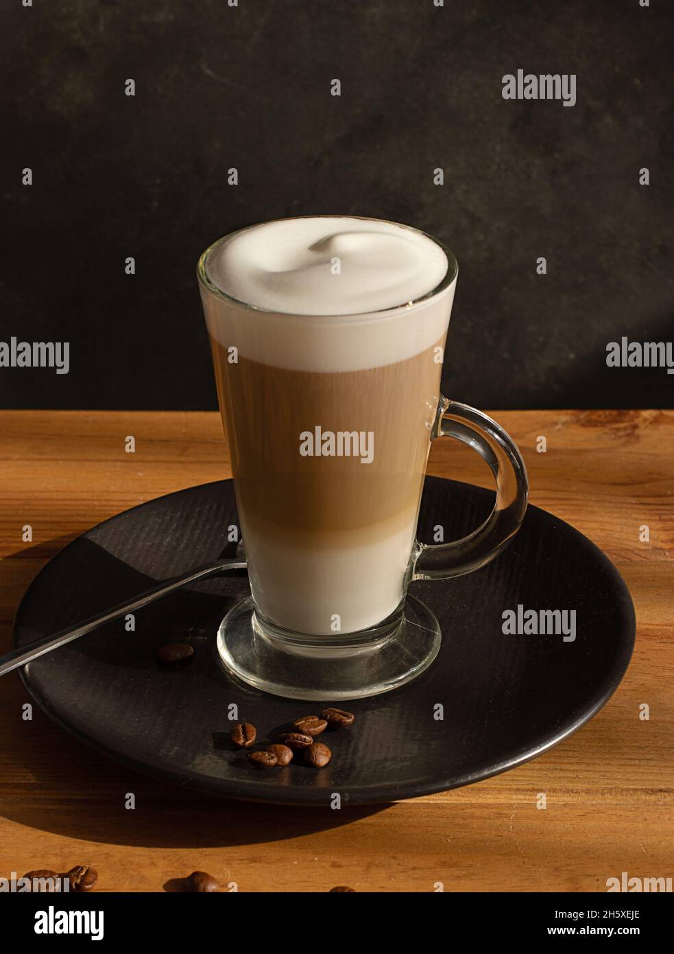 Glass of fresh hot aromatic latte coffee served on table Stock Photo