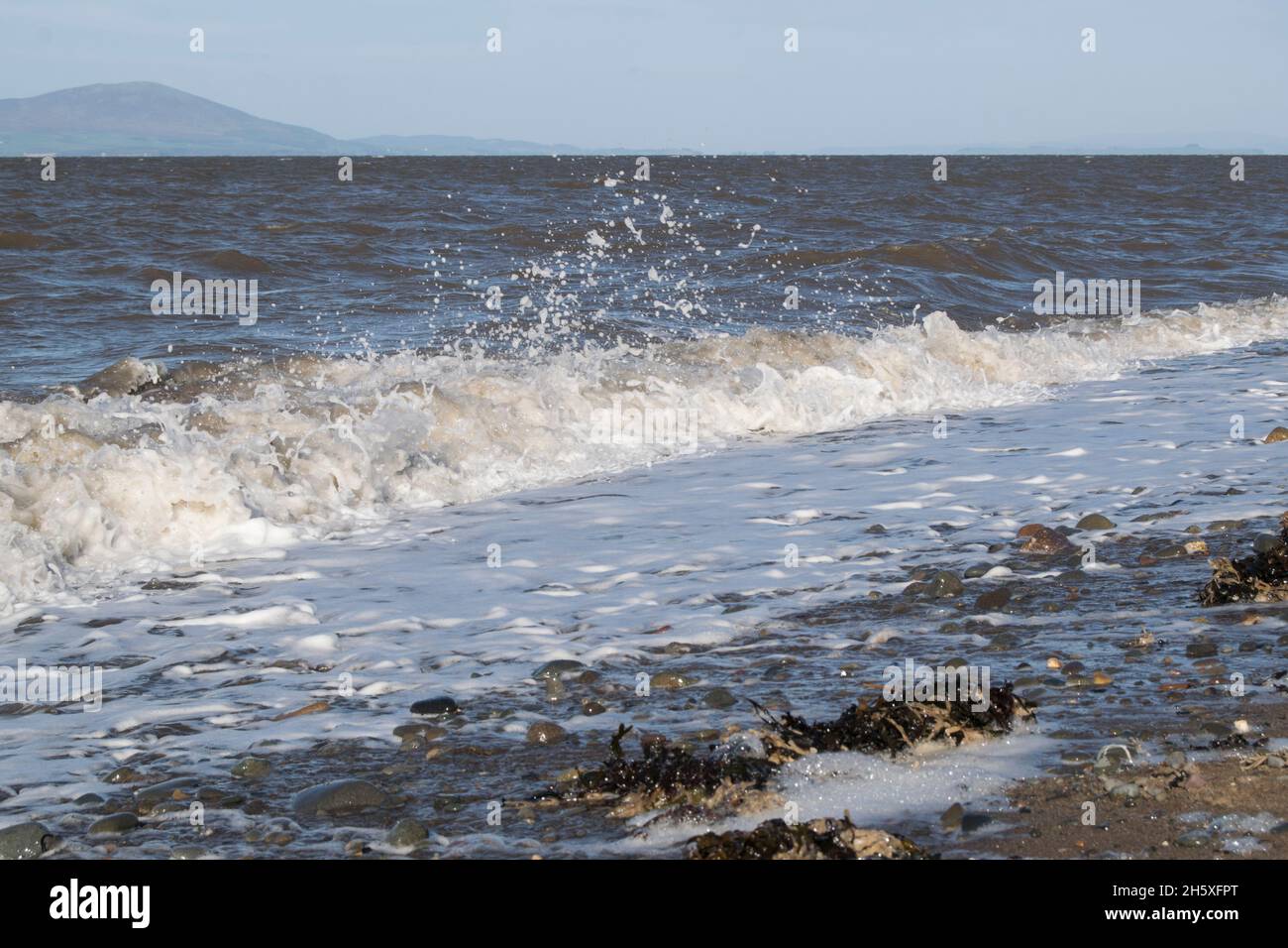 Waves on the Solway coast crashing on the shoreline Stock Photo