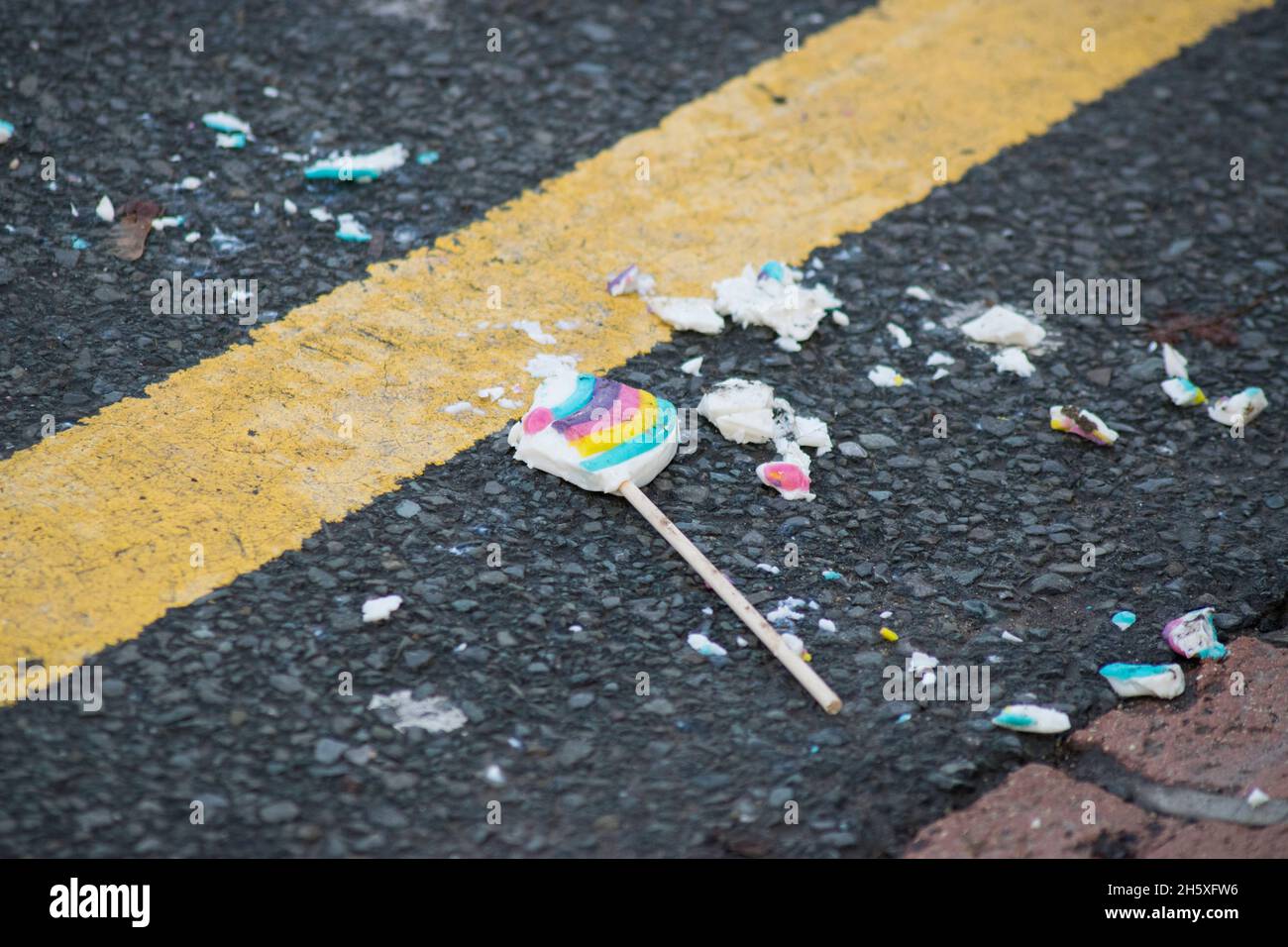Colorful lollipop dropped and broken on the road Stock Photo