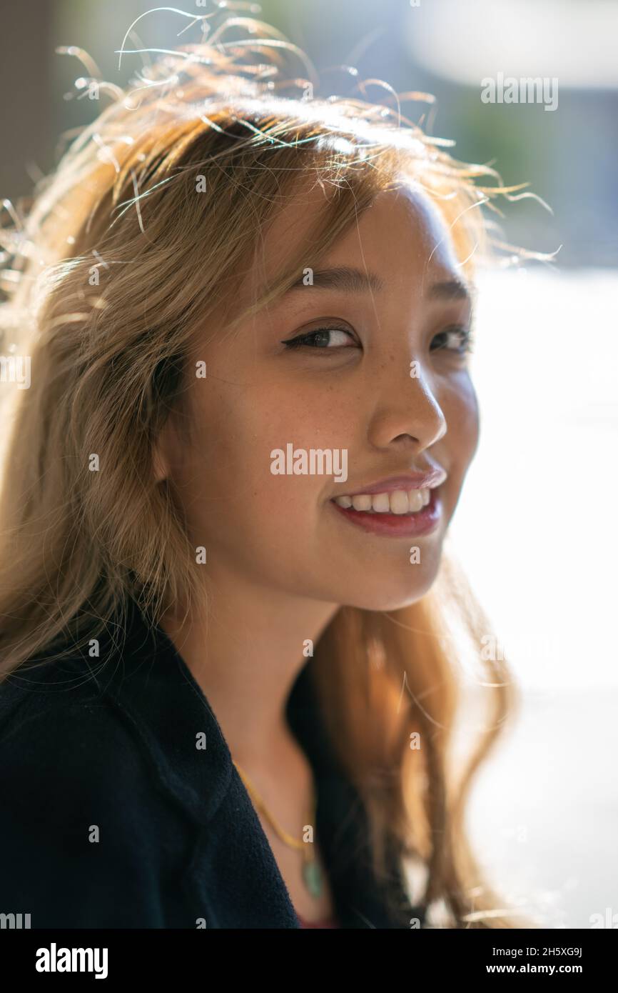 Closeup portrait of a young smiling Filipina woman in fall wardrobe Stock Photo