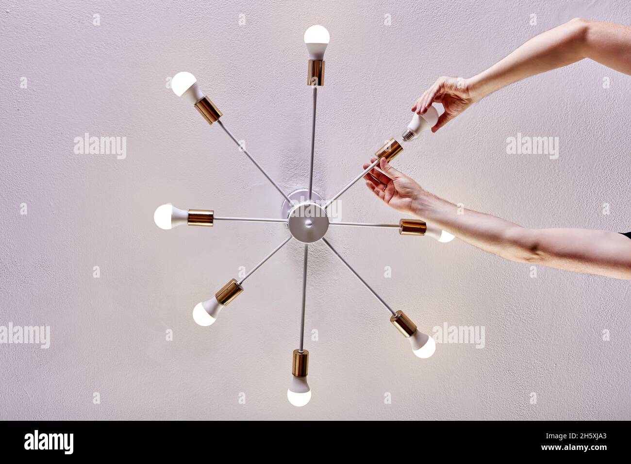 Light bulb replacement of ceiling lighting fixture in home Stock Photo