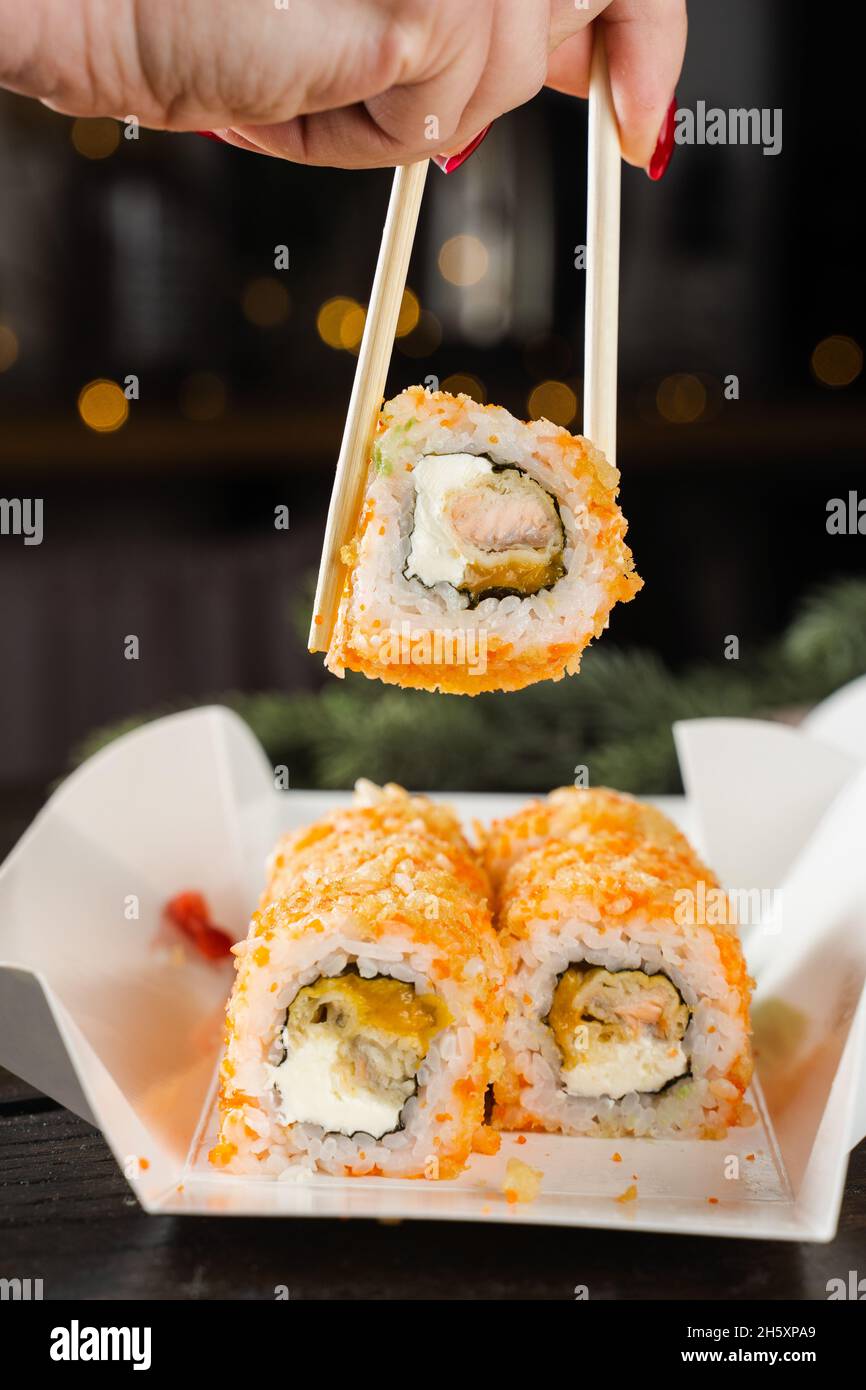 Sushi and roll food delivery at new year eve. Christmas celebration with  roll with salmon, mango and soft cheese Stock Photo - Alamy