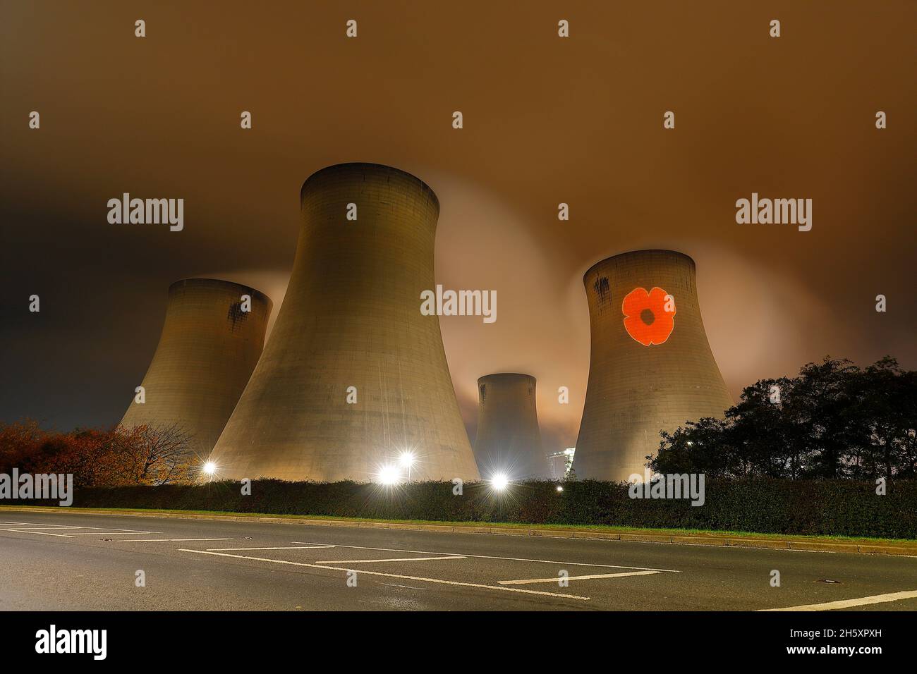 An illuminated poppy beamed onto one of the cooling towers of Drax Power Station in North Yorkshire, to mark remembrance day. Stock Photo