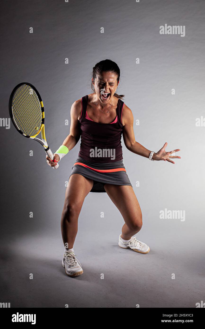 Professional female tennis player. Happy girl screaming with racket in  hands Stock Photo - Alamy