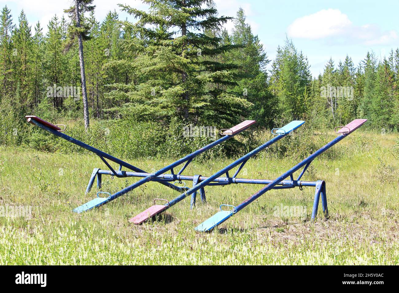 Old unmaintained teeter totters in an abandoned playground Stock Photo