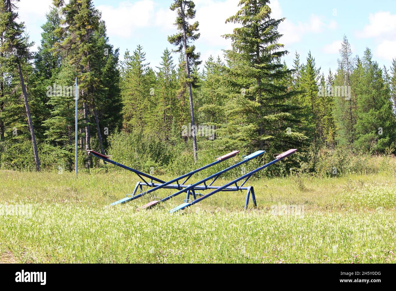 An old teeter totter sits alone in a field Stock Photo