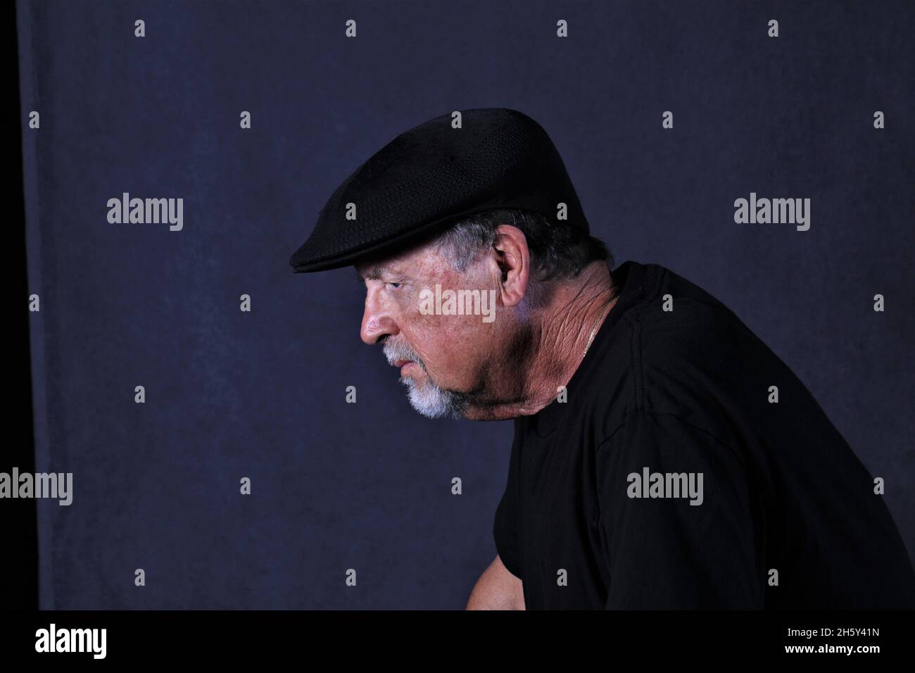 younger senior with cap and black background Stock Photo - Alamy