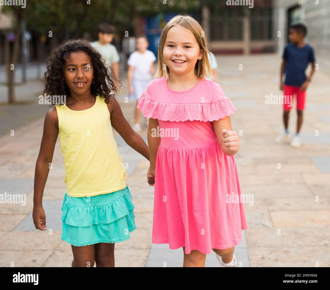 Two young girls walking hand in hand Stock Photo - Alamy