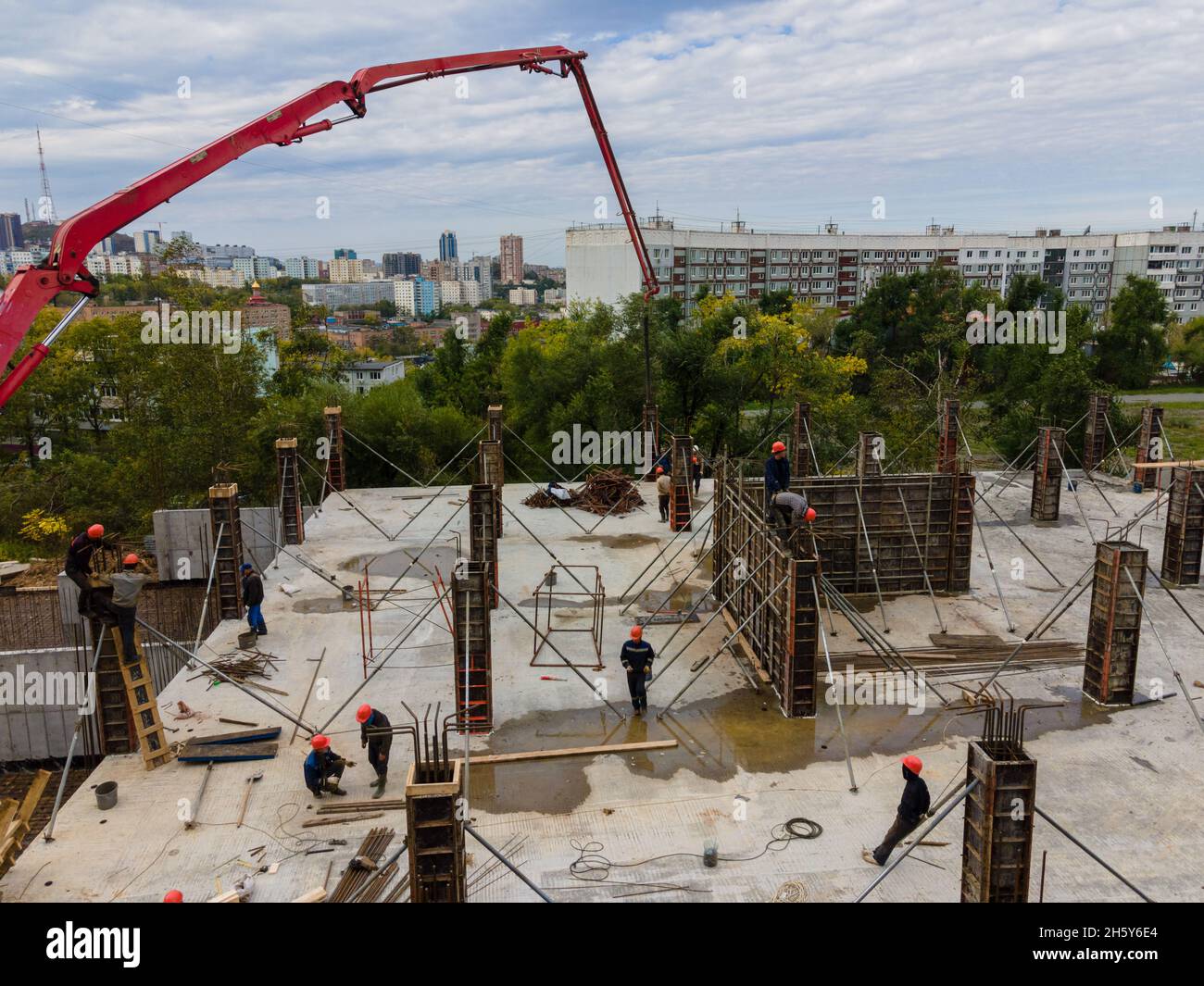 Feeding the working mixture of concrete to the construction site with a concrete pump for pouring the foundation. Stock Photo