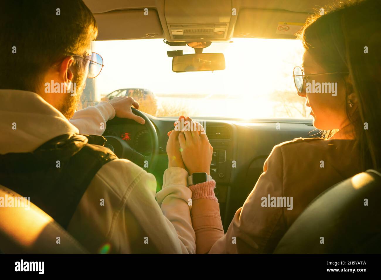 Romantic Couple enjoy road trip in car. Lovers holding hands against