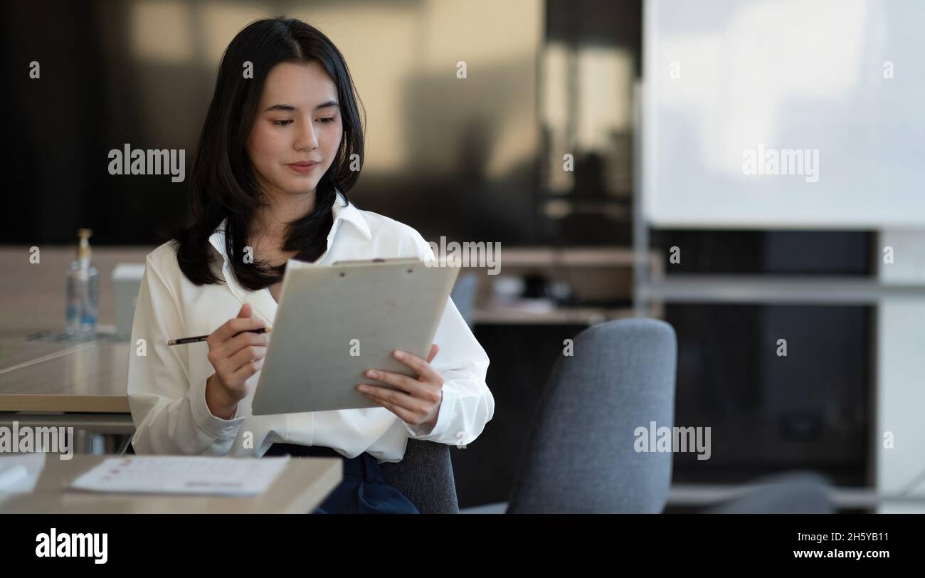Portrait of successful young Asian businesswoman working with financial ...