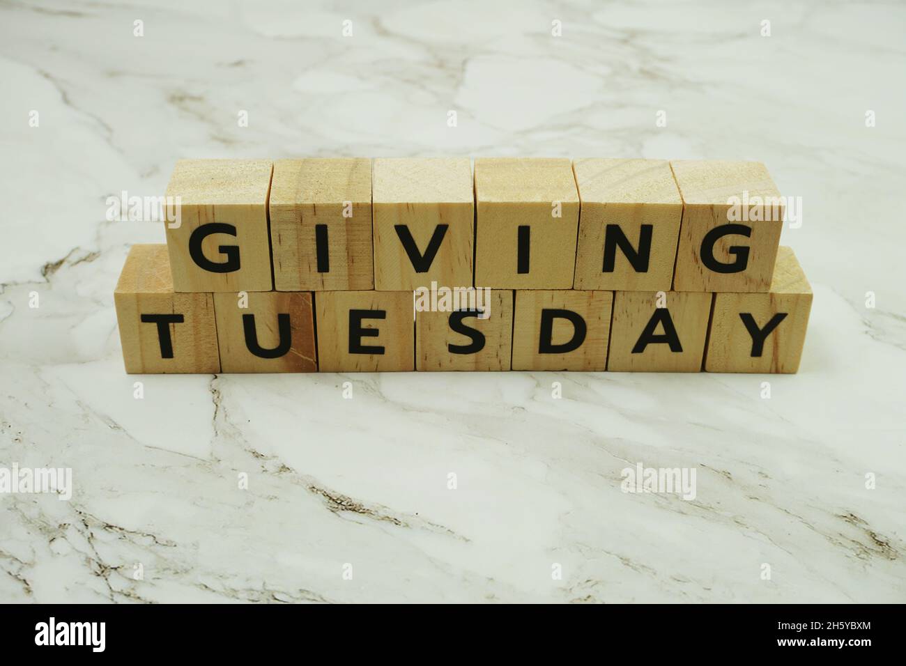 Giving Tuesday alphabet letter on marble background Stock Photo