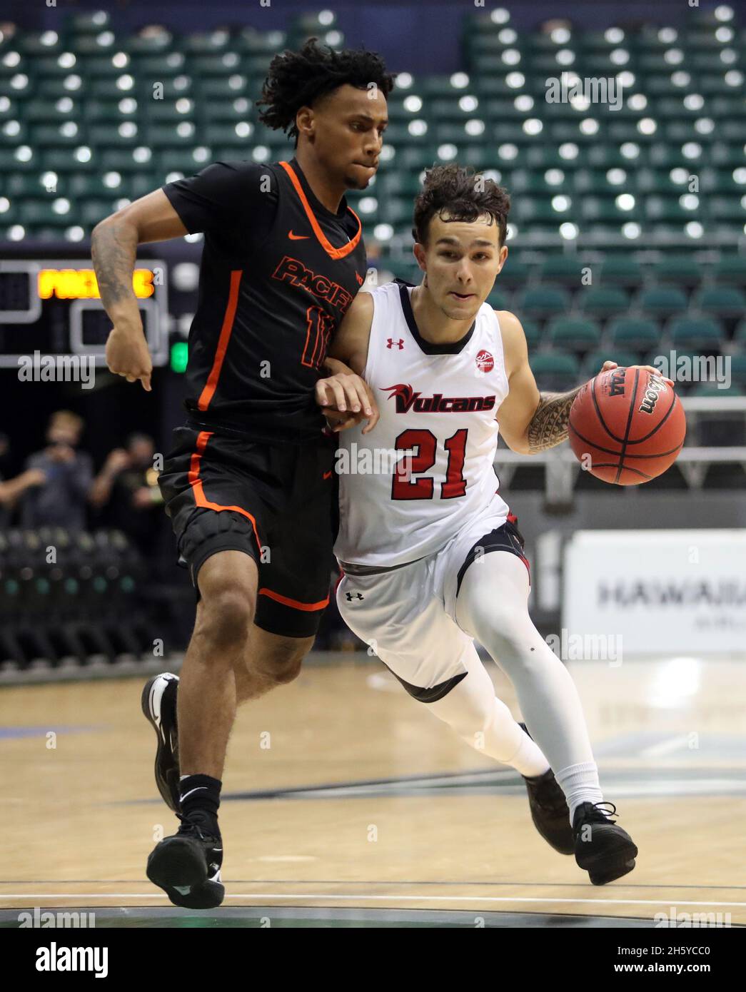Honolulu, USA. 11th Nov, 2021. November 11, 2021 - Hawaii-Hilo Vulcans guard Kameron Ng #21 drives the lane against Pacific Tigers guard Jaden Byers #11 during a game between the Hawaii-Hilo Vulcans and the Pacific Tigers during the Rainbow Classic at the SimpliFi Arena at the Stan Sheriff Center in Honolulu, HI - Michael Sullivan/CSM Credit: Cal Sport Media/Alamy Live News Stock Photo