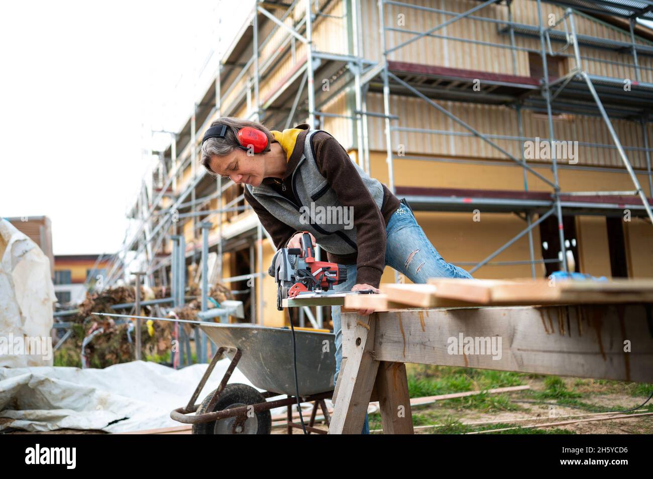 Hitzacker, Germany. 03rd Nov, 2021. Heike Metze saws wood in the Hitzacker village. About 300 people want to live together in a housing project one day. The special feature of the concept: one hundred young, one hundred old and one hundred refugees could live together. Credit: Philipp Schulze/dpa/Alamy Live News Stock Photo