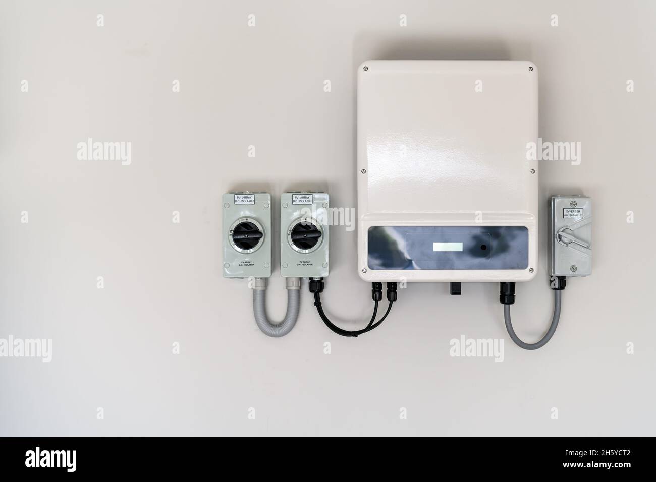 New solar panel inverter with isolators attached to the wall Stock Photo