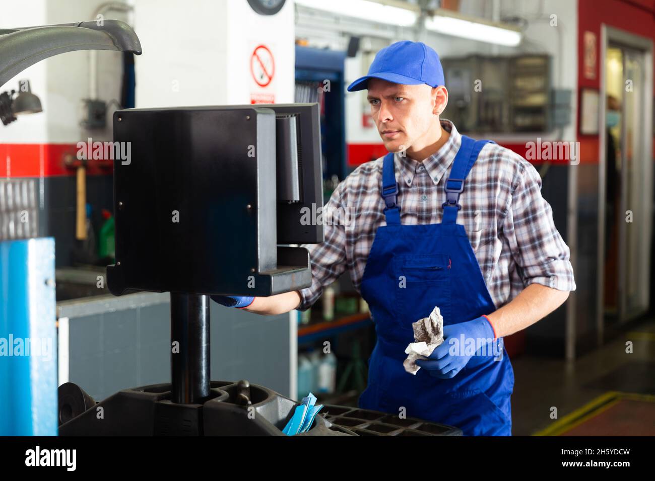 Mechanic balancing wheel with machine balancer at auto service Stock ...