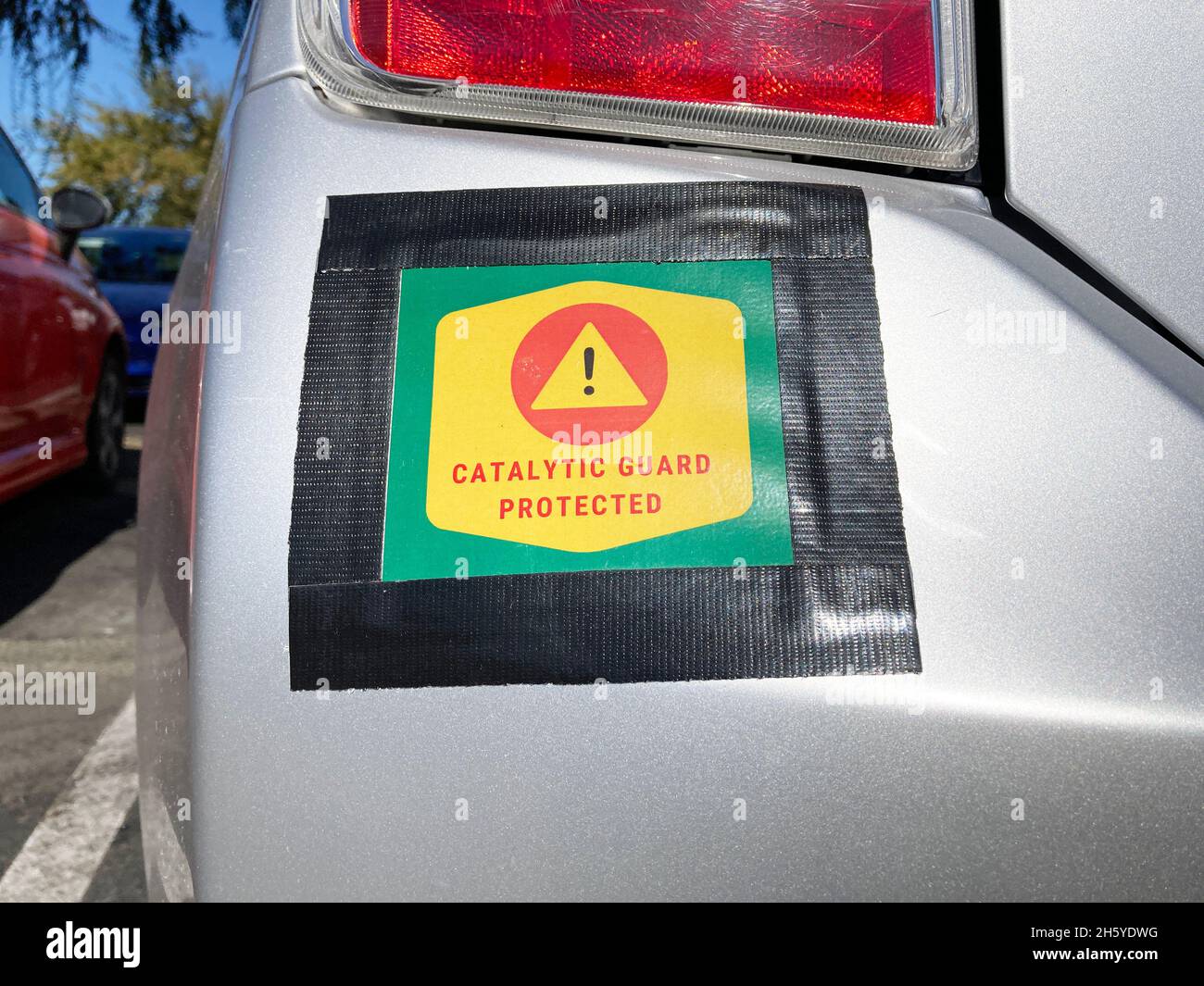Catalytic Guard Protected sign on vehicle bumper. Catalytic converter theft prevention Stock
