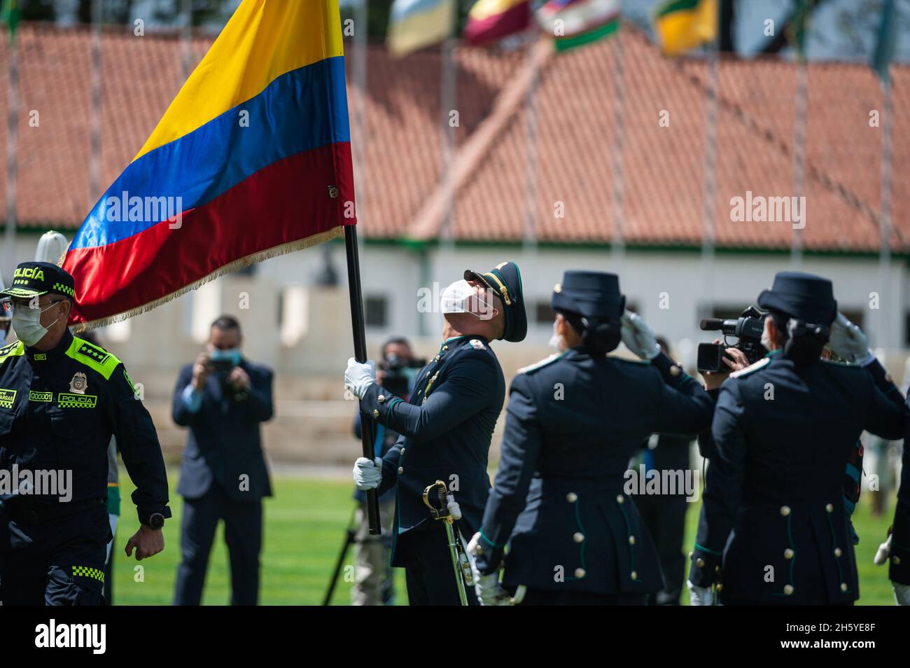 Bogota, Colombia. 11th Nov, 2021. Colombia's president Ivan Duque Marquez carries a Colombian flag and hands it to a officer during an event were Colombia's president Ivan Duque Marquez and Colombia's Minister of Defense Diego Molano in conmmemoration of the 130 anniversary of Colombia's National Police and the promotion to officers to more than a 100 police members, in Bogota, Colombia on November 11, 2021. Credit: Long Visual Press/Alamy Live News Stock Photo