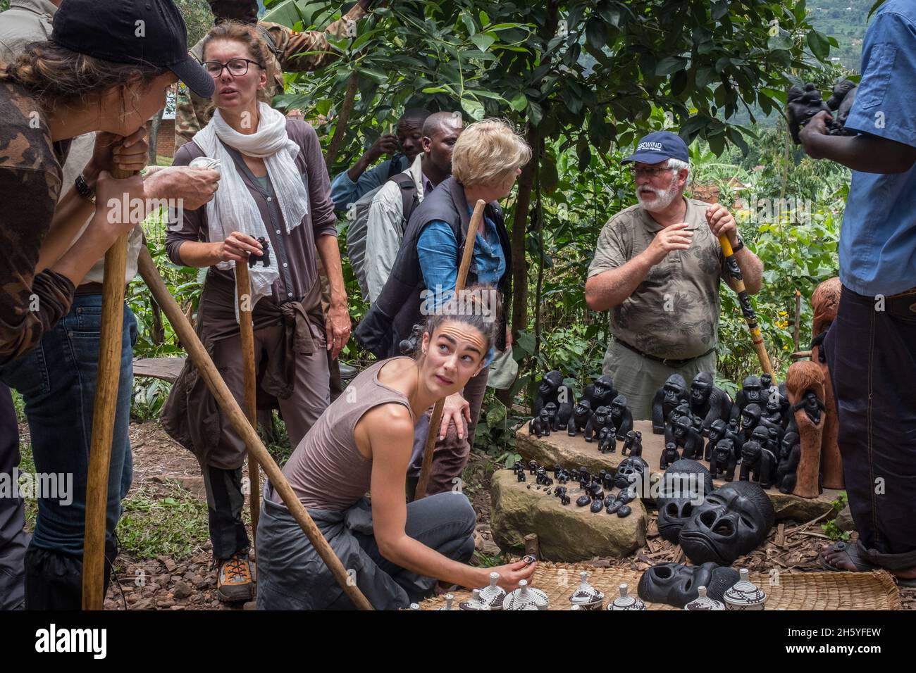 September 2017. Tourists after a gorilla tracking tour considering local handicrafts produced and sold along the trails in and out of Biwindi Impenetrable National Park. Bwindi Impenetrable National Park, Uganda. Stock Photo