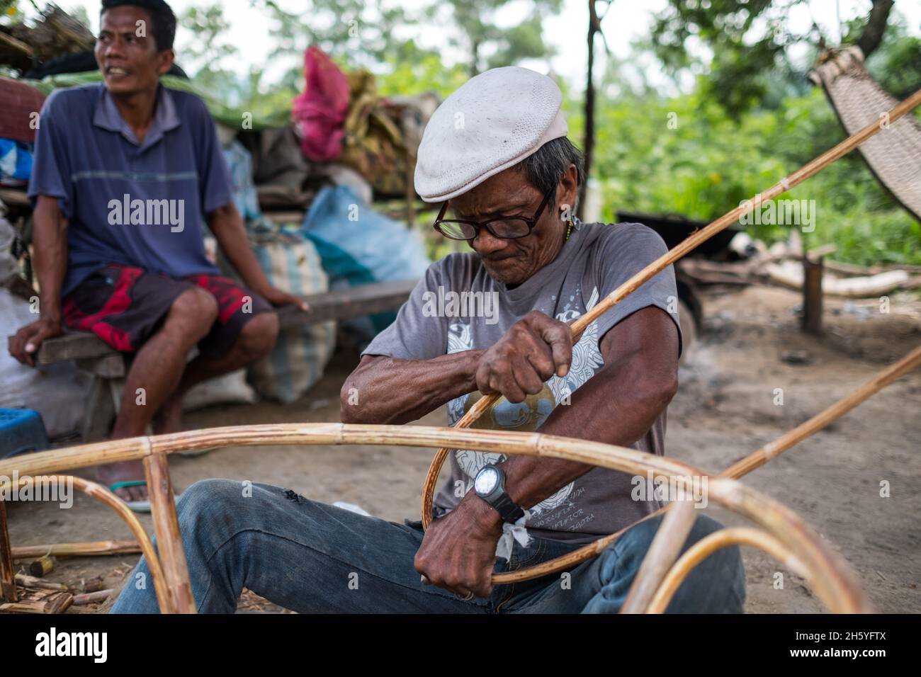 July 2017. Arenesto Deguen making an infant's walker from ratan. Local handicrafts like this add value over simply harvesting the ratan, but are difficult to market and capitalize on without a better distribution system. Aborlan, Barangay Sagpangan, Palawan, Philippines. Stock Photo