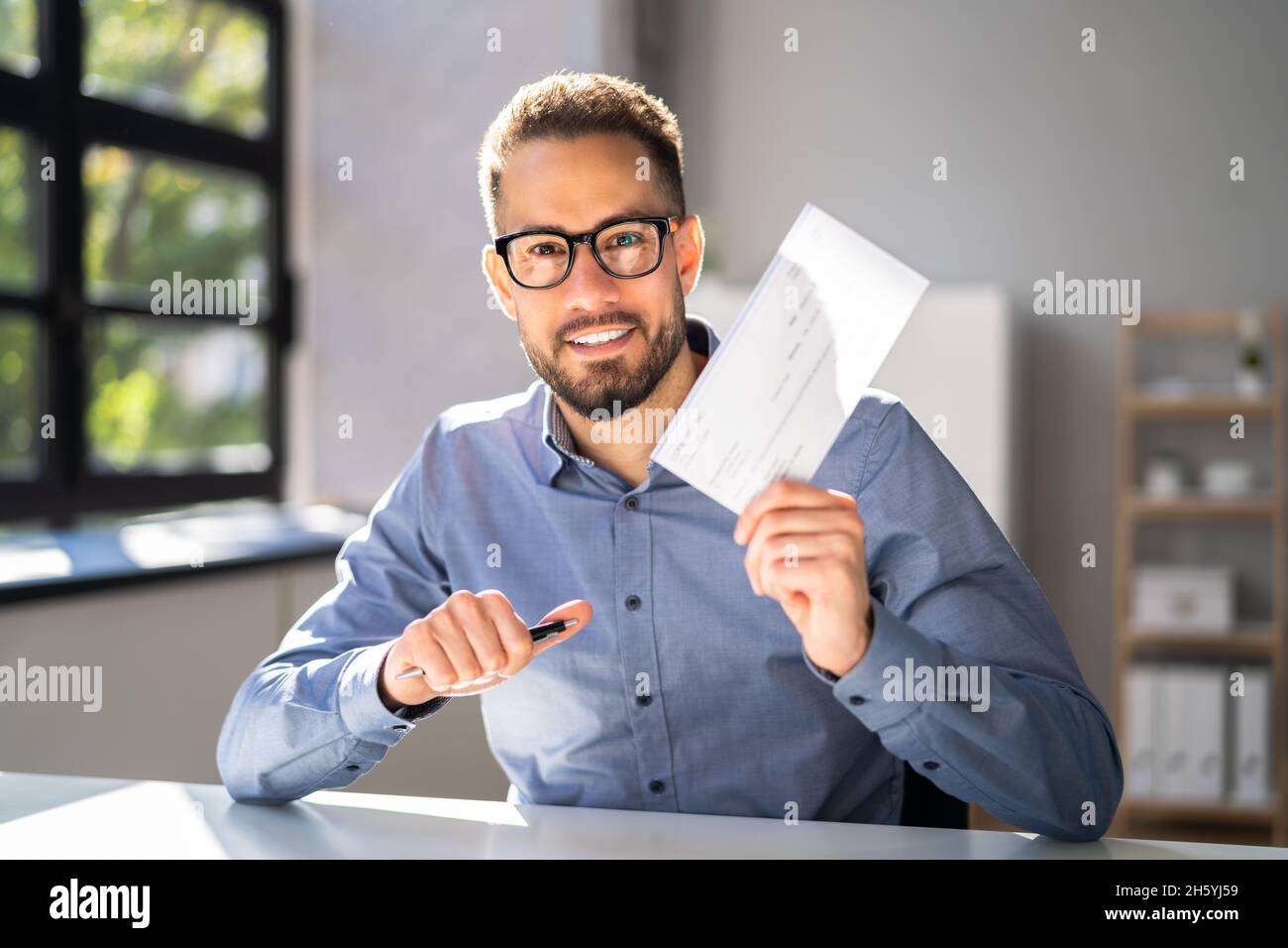 Holding Paycheck Or Payroll Check Or Insurance Cheque In Hand Stock Photo Alamy