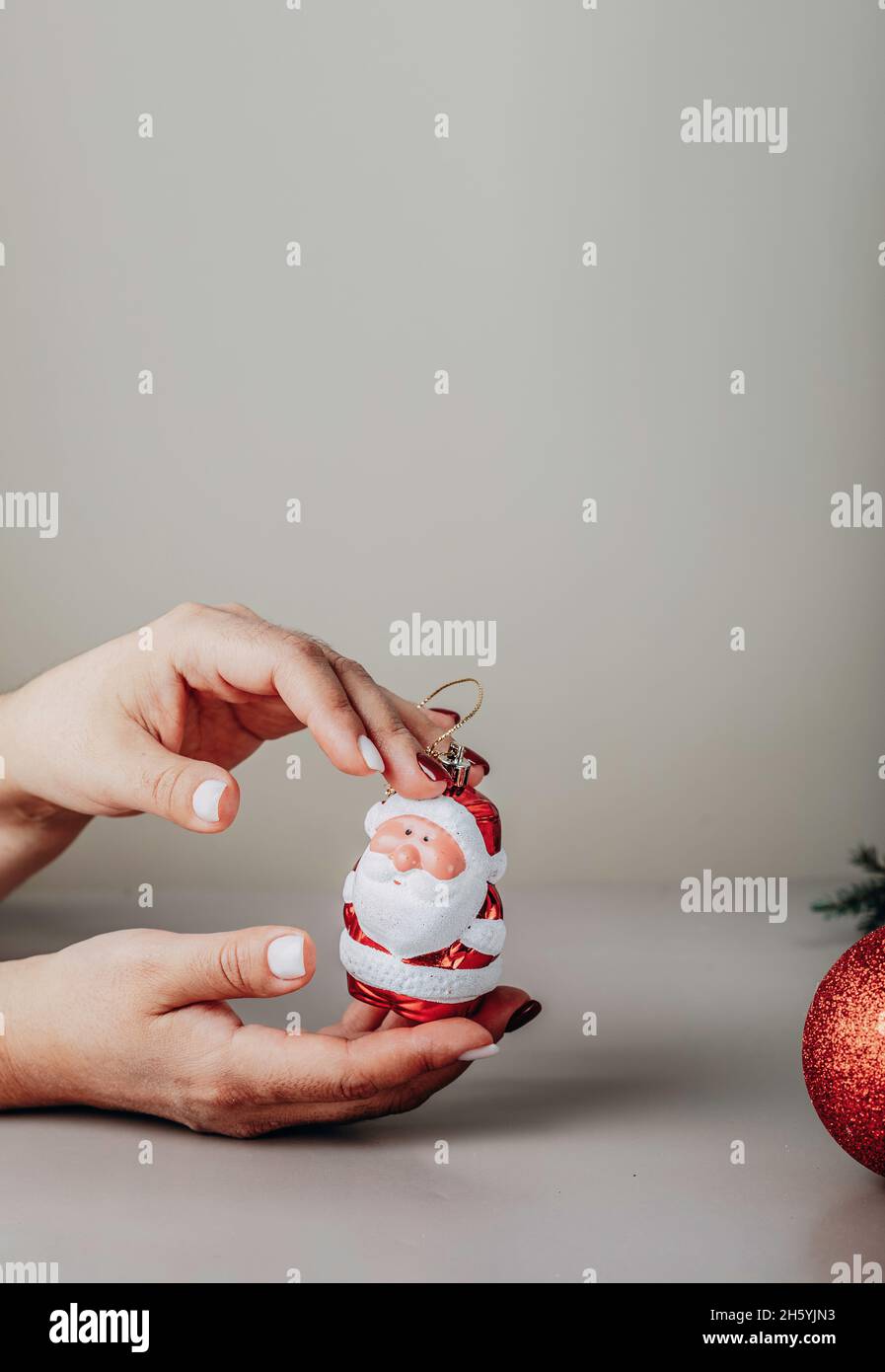 Preparing for the New Year holidays. New Year's manicure. Santa claus figurine in hands Stock Photo