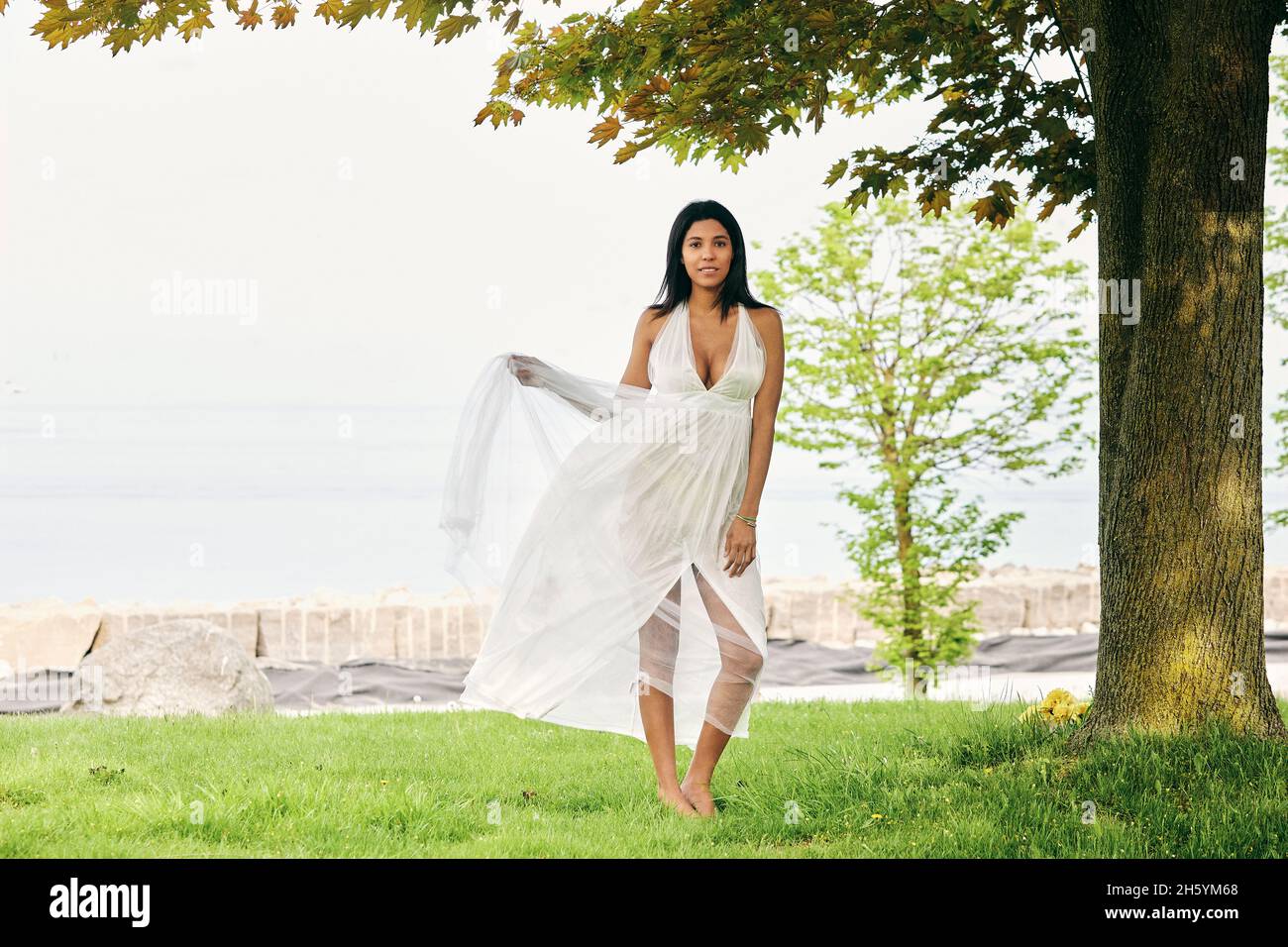Strolling amidst nature's beauty: A Latina woman relishes her walk by the lake Stock Photo
