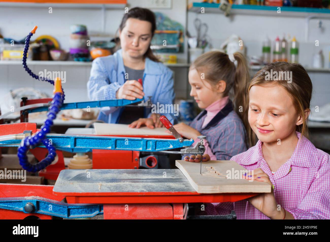Schoolgirls learning to carve wood during arts and crafts class Stock