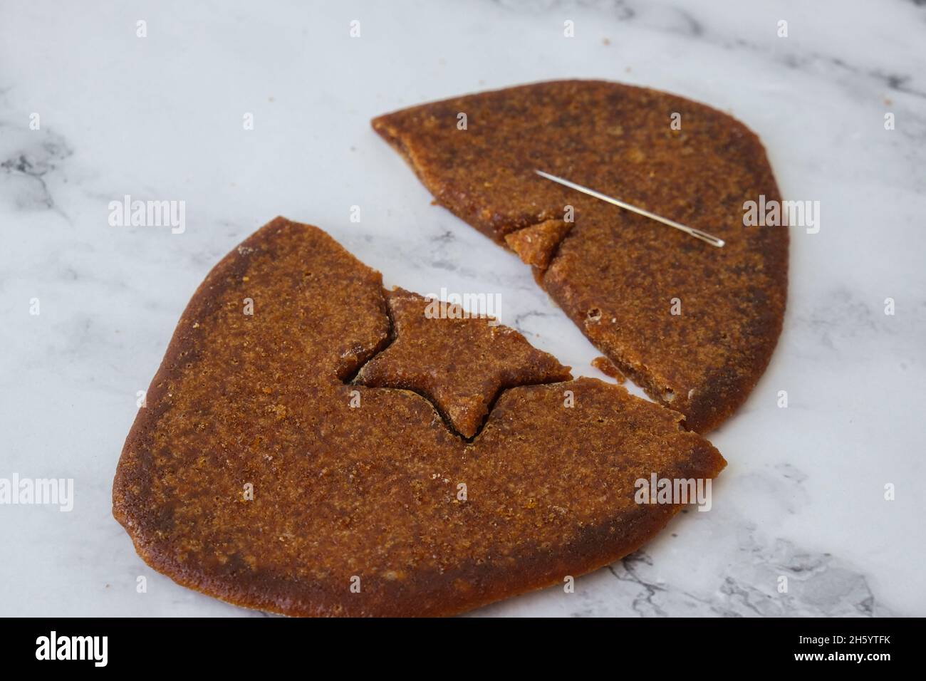 Kiev Ukraine - October 2021 Playing Korean Dalgona or Ppopgi honeycomb candy from Squid Game challenge. Star shape. Homemade sugar candy. Failed game. Stock Photo