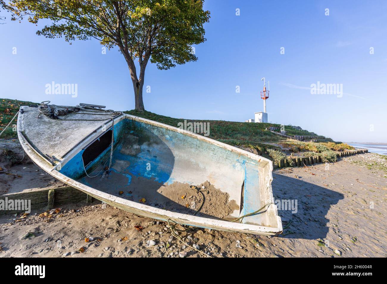 Rowboat moored on the jetty bordering the Somme river and its bay. Saint-Valery, Bay of Somme, France Stock Photo