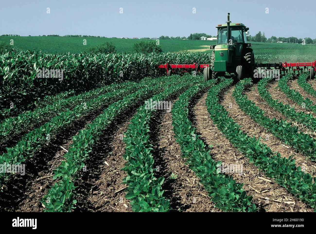 Farmer in a John Deere tractor plowing a field on his farm ca. 2011 or ...