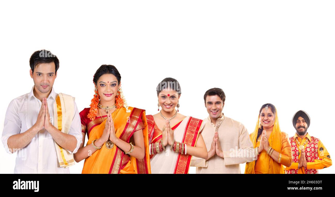Indian couple of different state and cultures standing in a row and greeting with hands joined. Stock Photo