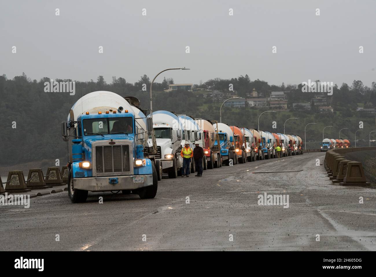 A long line of concrete trucks wait on the top of Oroville Dam to