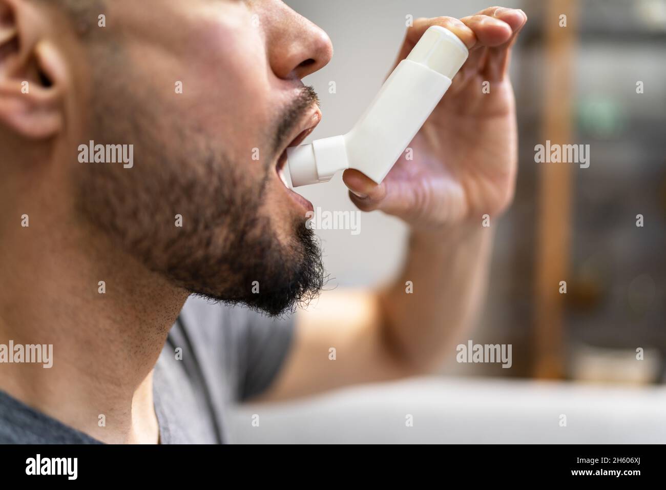 Man With Asthma Using An Asthma Inhaler For Preventing Attacks Stock Photo