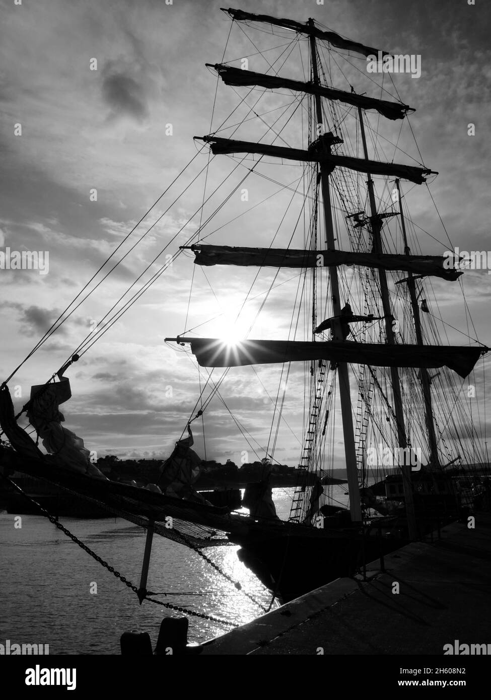 Silhouette of a classic ship in sunset light. High contrast black and white photograph. Stock Photo