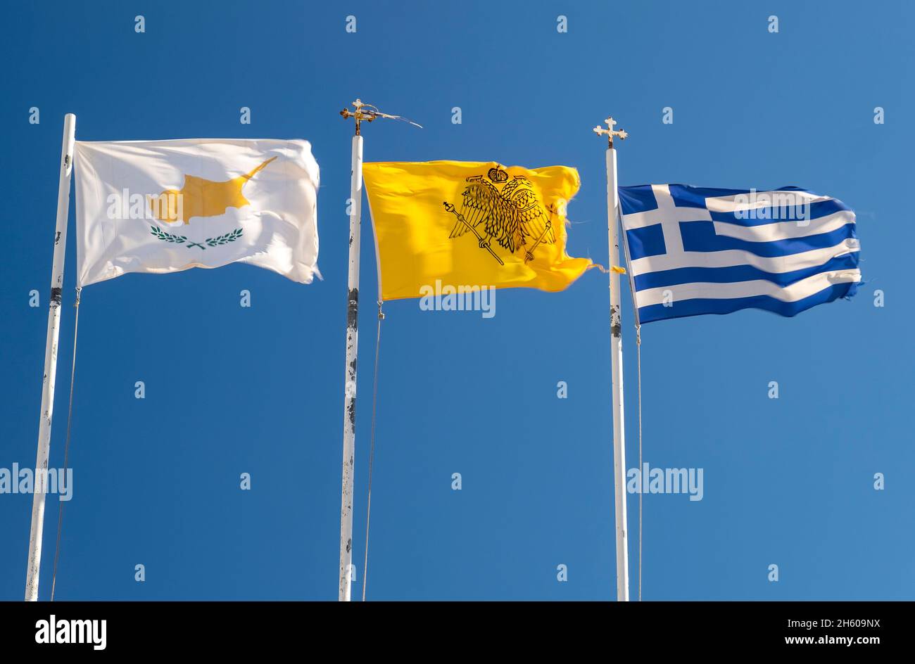 Three flags, flag of Cyprus, church of Cyprus flag and Greek flag flying over the Agios Nikolaos church, Pernera, Protaras, Cyprus. Stock Photo