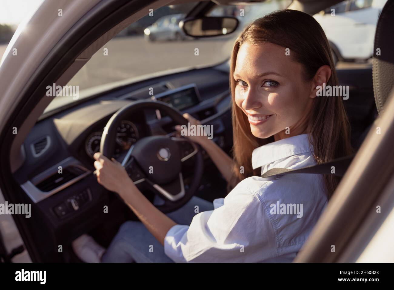 Photo of pretty shiny young woman wear white shirt driving car hands