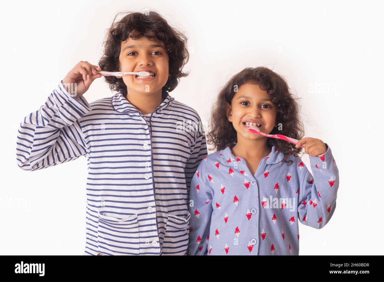 Portrait of Sibling brushing teeth together with toothbrush Stock Photo