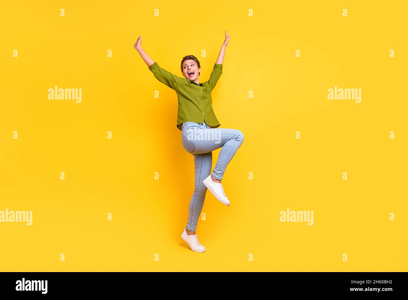 Photo of excited funny dream lady dance look empty space wear green shirt isolated yellow color background Stock Photo