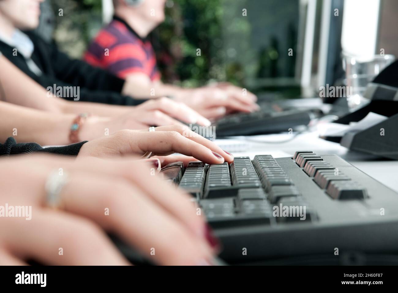 Ein Callcenter in Deutschland im Vordergrund Hände auf Tastaturen. Personen sind nicht zu erkennen. Stock Photo