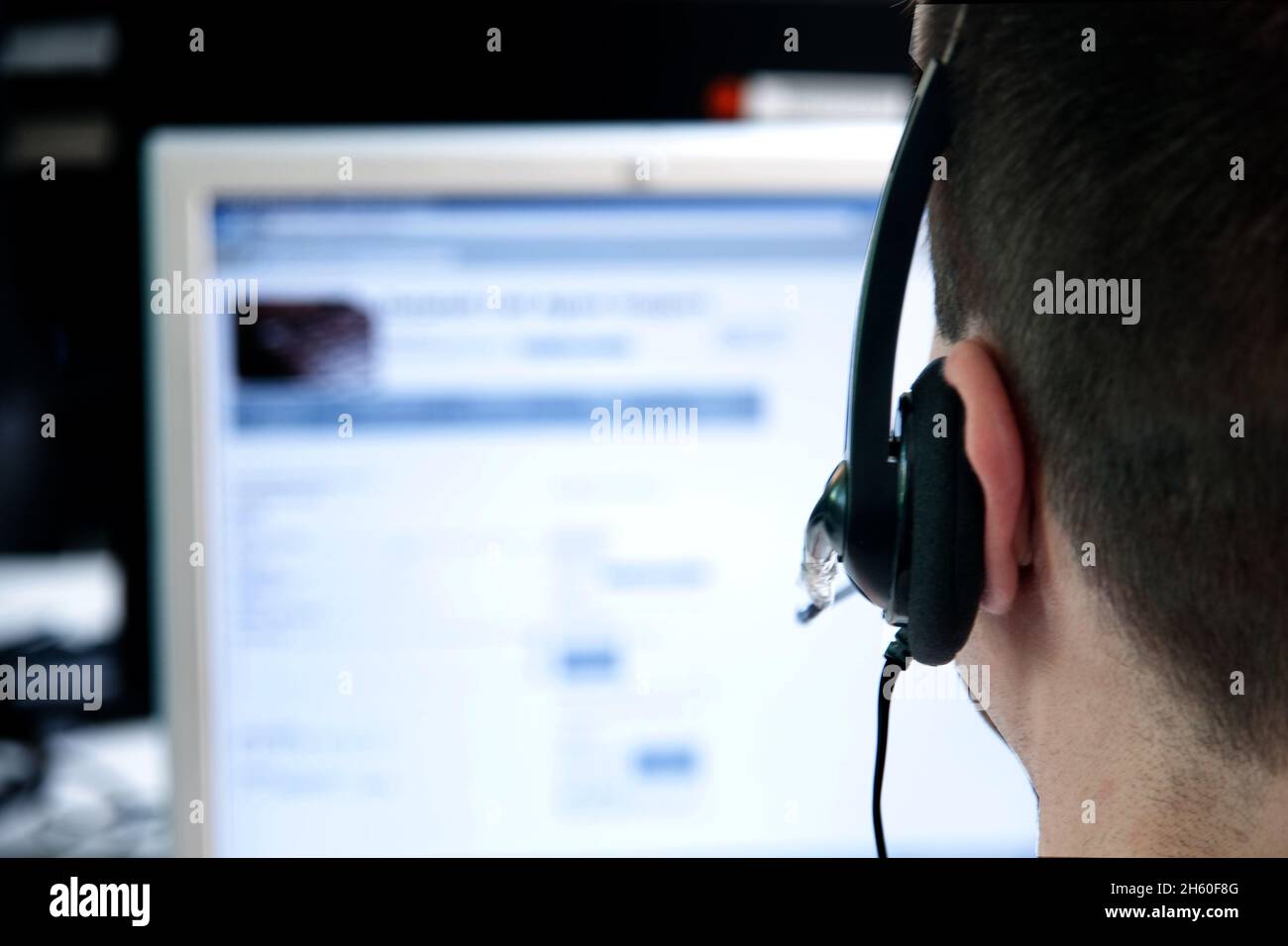 Callcenter in Deutschland, männliche Person mit Headset, nicht zu erkennen,  telefoniert mit Kunden. Stock Photo