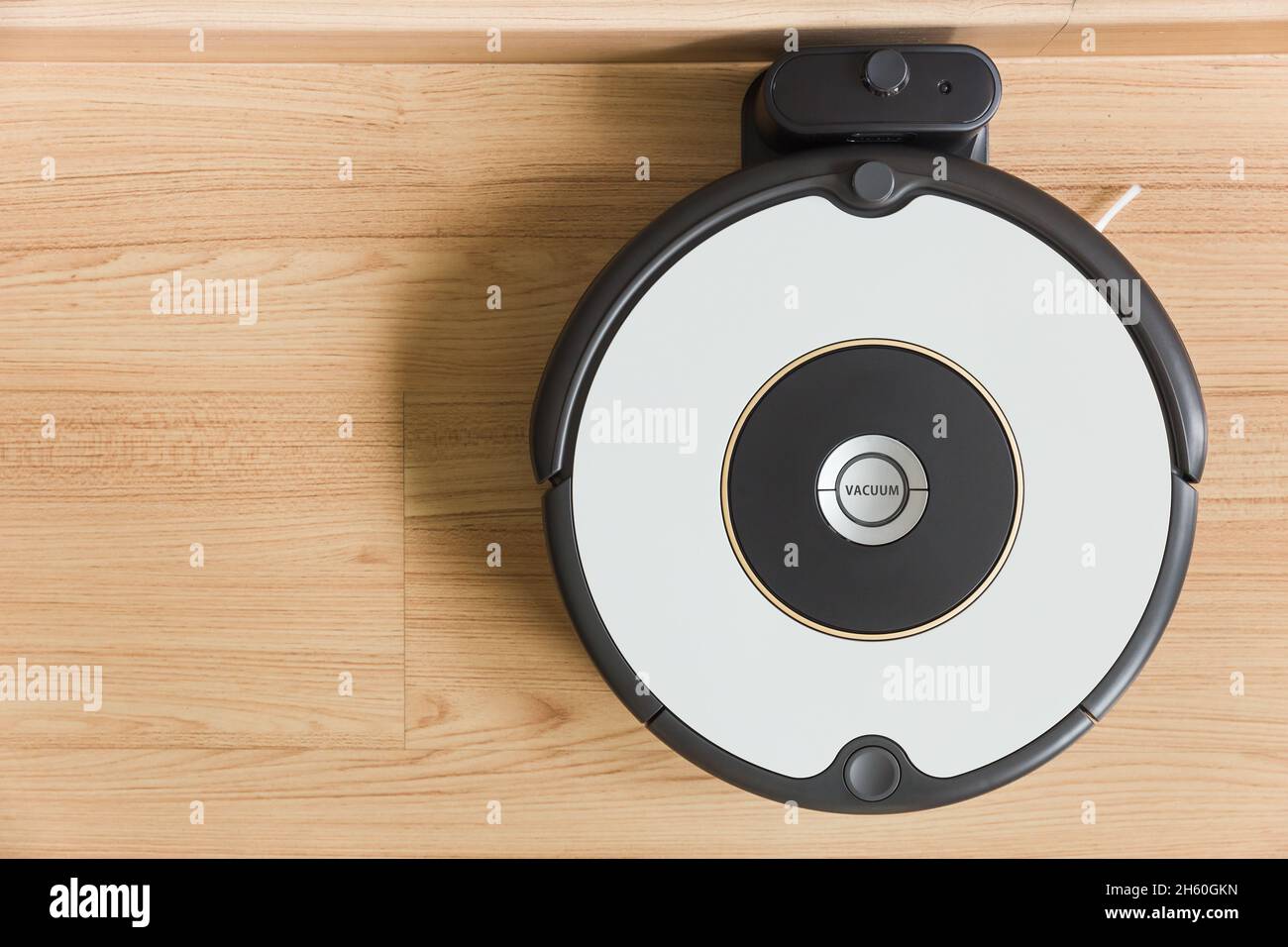 Topview Auto robot vacuum, park at dock battery charge station with wooden space for text. Stock Photo