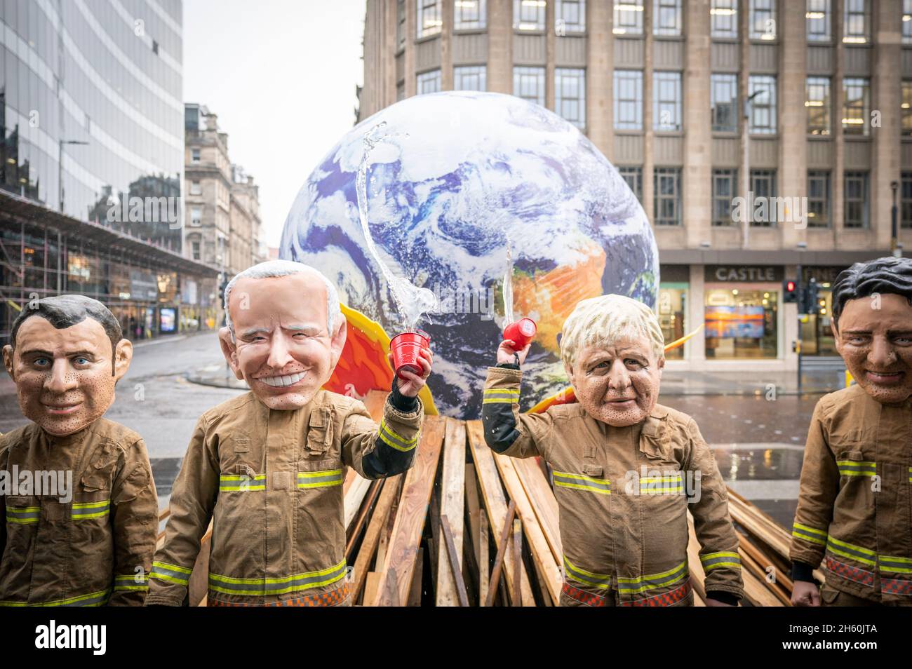 Campaigners wearing 'big heads' of world leaders, including Emmanuel Macron, Joe Biden, Boris Johnson and Justin Trudeau gather for Oxfam's 'Ineffective Fire-Fighting World Leaders' protest performance during the official final day of the Cop26 summit in Glasgow. Picture date: Friday November 12, 2021. Stock Photo