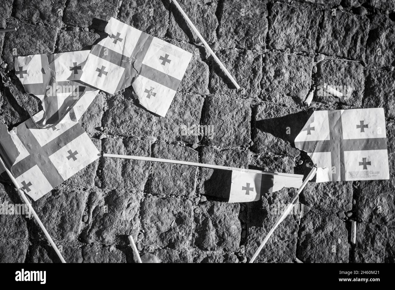 Many teared apart georgian flags on pavement. Crisis in caucasus concept. B&w background banner Stock Photo