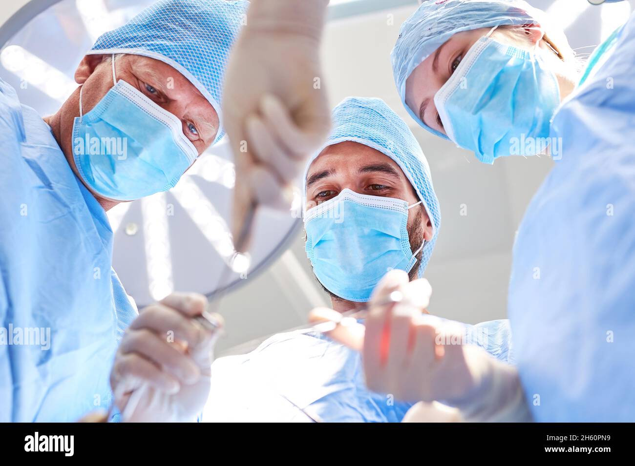 Surgeons Operating Process Three surgeons in the operating room are concentrating on a surgical ...