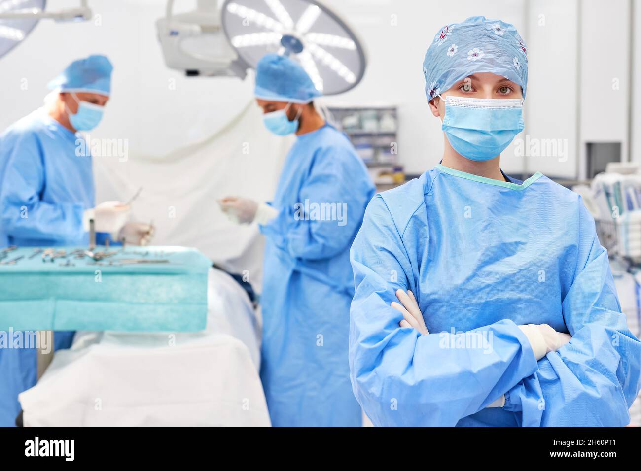 Young doctor or operating room nurse with crossed arms in operating ...