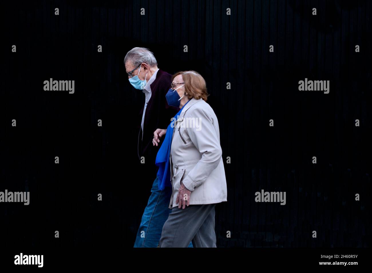 Old couple in the street wearing face masks, Barcelona, Spain. Stock Photo
